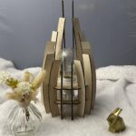 Lampe en bois dubaï, couleur brute avec sa propre ampoule éteinte. Posée sur une nappe en velour à côté d'un lapin 3D et d'un vase avec des fleurs en bois