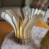 Lampe en bois Luma, composée de plusieurs lamelle et d'un led en son centre ppour illuminer. Posée sur une table basse