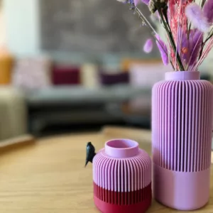 Vase Solea emboîtable posé sur une table de chevet. Le grand vase contient des fleurs violets. Décoration unique pour vos salons