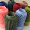 Vases Solea emboïtables avec différents coloris sur une nappe en fourrure..