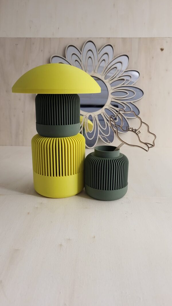 3 vases Solea emboîtables avec un châpeau de couleur jaune. Il y a un vase de taille moyen jaune avec un vase petit au dessus de lui de couleur vert. Les combinaisons sont multiples avec nos vases Solea, en fonction de la taille, de la couleur et des accesoires que vous y mettez. Une décoration unique pour embellir votre intérieur. Les vases sont conçu dans nos ateliers à Sarrigné.