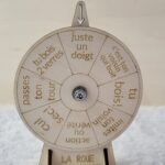 Roue de la mort en bois, avec 8 gages différents gravés. Installé de face sur une nappe en velour