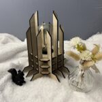 Lampe Luxor en bois moderne. Elle est réversible avec ses deux couleurs noir et blanc. La lampe est posée sur une nappe en velour avev un écureuil en 3D et un pot de fleur à côté