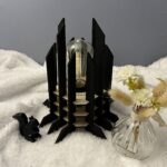 Lampe Luxor en bois moderne. Elle est réversible avec ses deux couleurs noir et blanc. La lampe est posée sur une nappe en velour avev un écureuil en 3D et un pot de fleur à côté