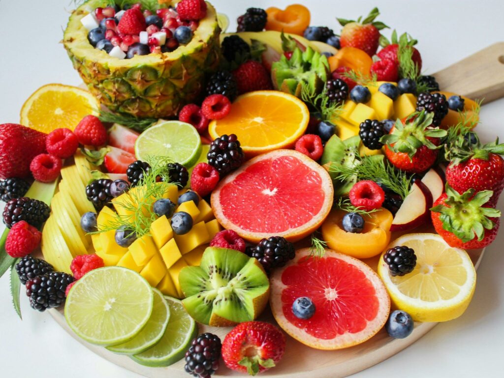 Assiette de fruis et légume frais à déguster. On peut y retrouver de l'ananas, de citron, du pamplemouse, des murs ou encore des fraises.