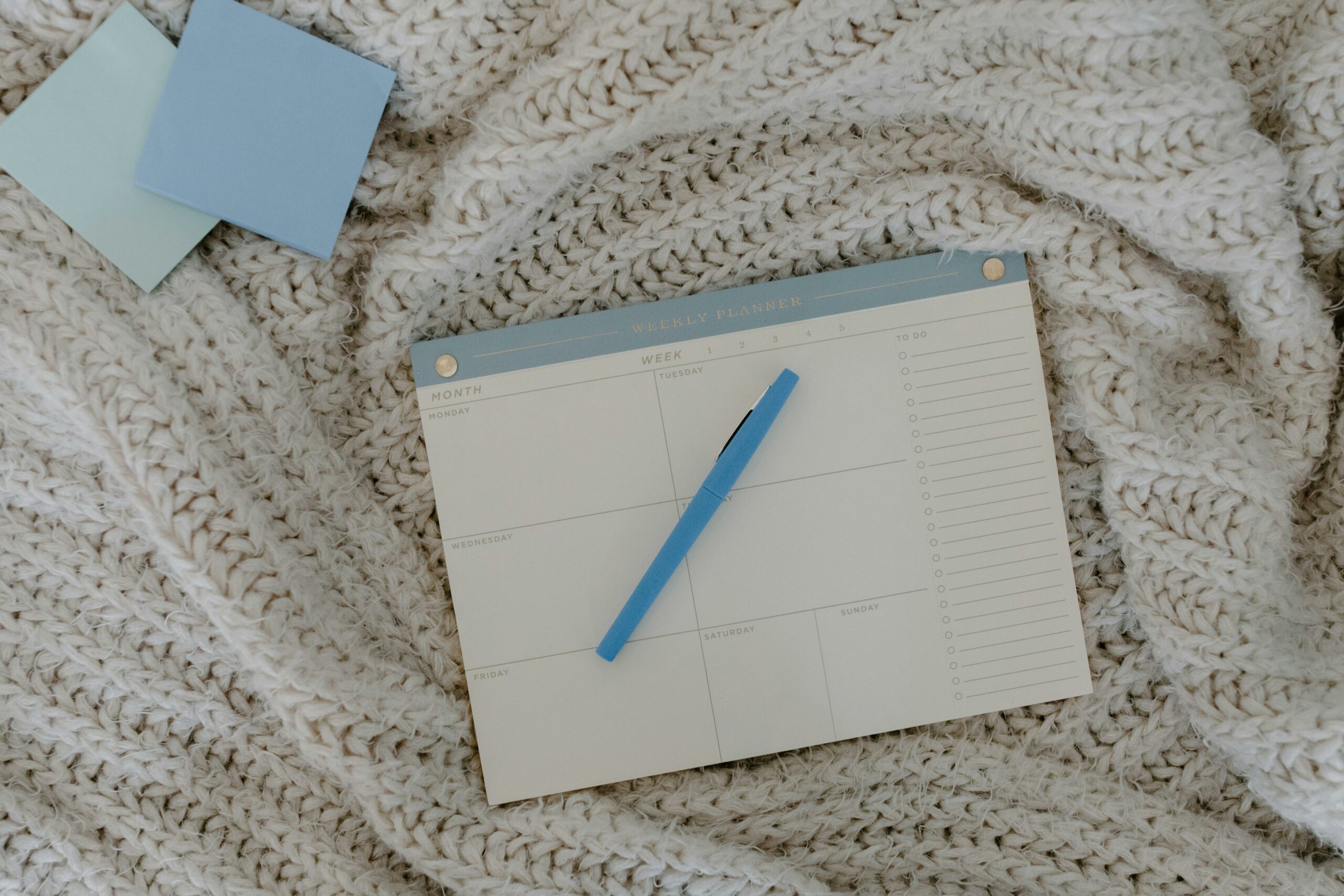 Calendrier posé sur un matelas avec un crayon dessus. Ce calendrier sert à organiser ses tâches de la journée pour éviter les chaleurs pendant la journée